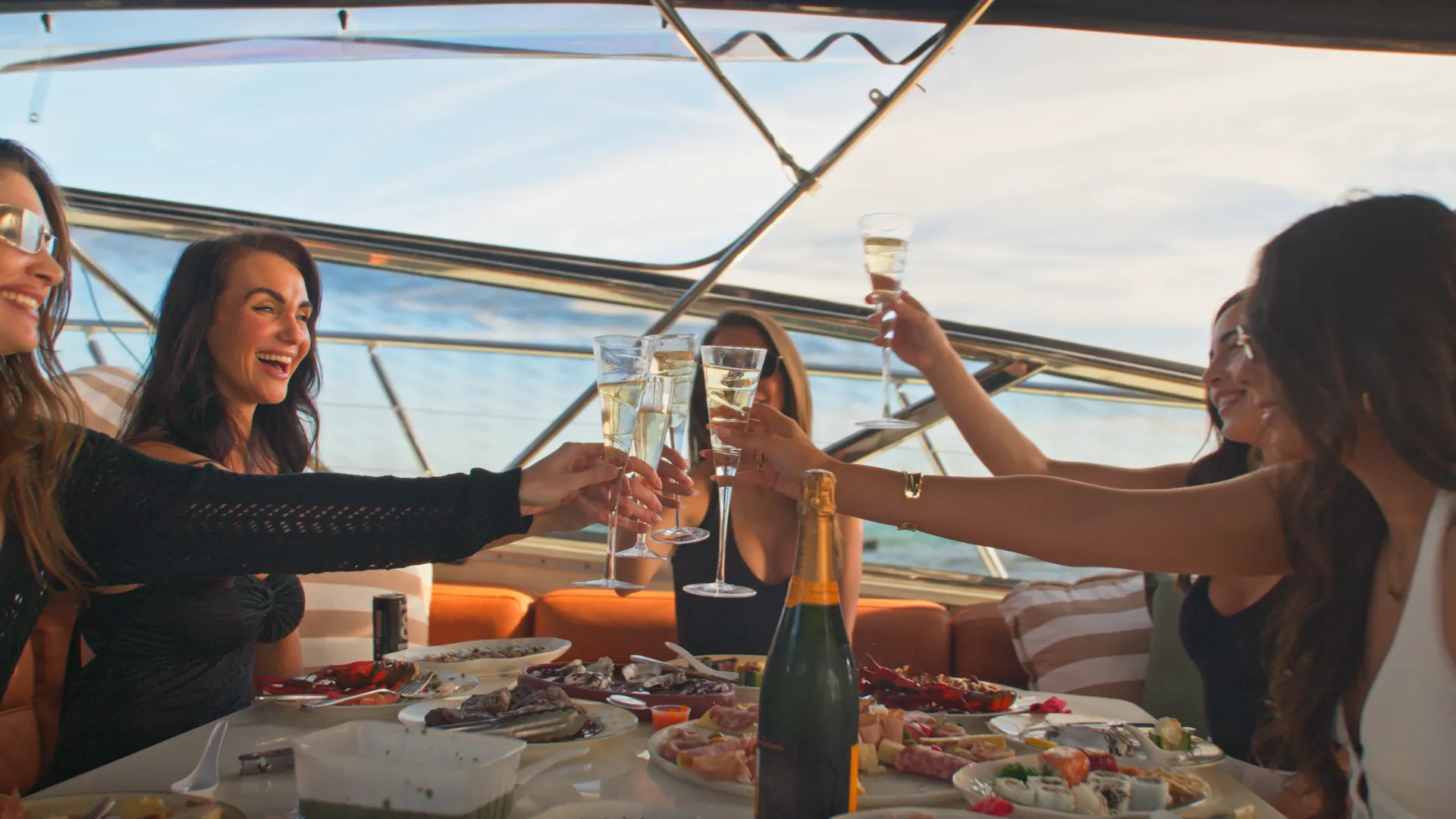 Hens party guests raising glasses on the Bote Charters yacht
